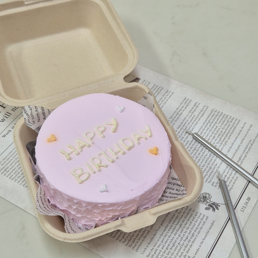 A cheap bento cake in Singapore that reads 'Happy Birthday' on pink, matte frosting